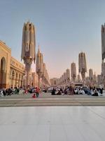 medina, saudi-arabien, 2022 - regenschirmkonstruktion auf dem platz von al-masjid an-nabawi oder der propheten-muhammed-moschee schützen die menschen tagsüber vor der sonne und arbeiten nachts als lichter foto