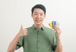 junger asiatischer Mann mit Kreditkarte foto