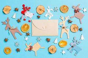 Blick von oben auf den Bastelumschlag auf blauem Hintergrund aus Weihnachtsdekorationen und Spielzeug. Weihnachtsschmuck-Konzept