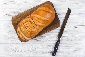 eine Scheibe Brot mit Messer auf einem Schneidebrett foto