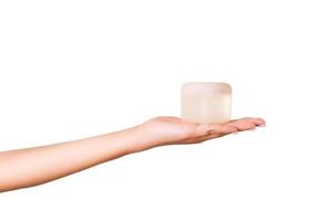 weibliche hand, die cremeflasche lotion lokalisiert hält. Mädchen geben Glaskosmetikprodukte auf weißem Hintergrund foto