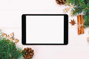 digitales tablet-modell mit rustikalen weihnachtlichen hölzernen hintergrunddekorationen für app-präsentation. draufsicht mit kopierraum. getönt foto