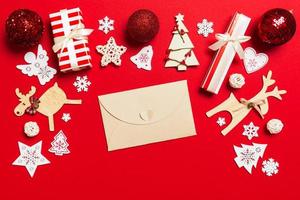 Draufsicht des Umschlags auf rotem Hintergrund. neujahrsdekorationen. weihnachtsferienkonzept