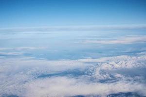 blauer bewölkter Himmel, Blick aus dem Flugzeugfenster. Luftaufnahme der Wolkenlandschaft foto