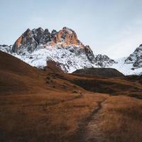 schöne Juta-Tal-Wanderroute mit malerischem, schneebedecktem Berghintergrund. Landschaft des Kazbegi-Nationalparks foto