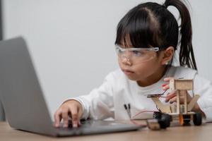 asia studenten lernen zu hause in der codierung von roboterautos und elektronischen platinenkabeln in stamm-, dampf-, mathematik-ingenieurwissenschaften-technologie-computercode im robotikkonzept für kinder. foto