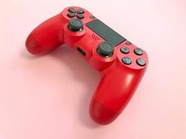 schöner roter digitaler moderner neuer spiel-joystick für computer-videospiele gamepad auf einem rosa hintergrund foto