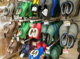 Regale im Laden. Galoschen. Waren in einem Supermarkt auslegen. Verkauf von Schuhen. foto