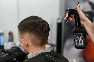 Ein Teenager in einem Schönheitssalon lässt sich die Haare schneiden, ein Friseur schneidet einem Teenager die Haare. foto
