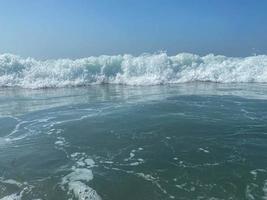 Wunderschönes Meer mit Wellen, die warmes, funkelndes, klares blaues Wasser in einem warmen, tropischen, orientalischen Land im Süden spritzen. Hintergrund, Textur foto