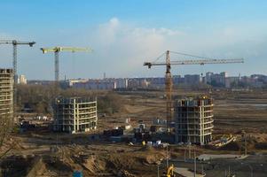 Draufsicht auf eine Großbaustelle mit Kränen und Gebäuden Häuser Beton monolithische Rahmenplatte mehrstöckige Wolkenkratzer der Großstadt der Metropole foto