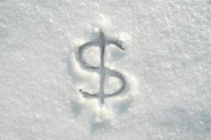 Dollarzeichen an einem sonnigen Wintertag in reinem Schnee geschrieben. Sicht von oben. foto