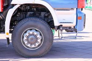 Ein großes schwarzes Gummirad mit einer LKW-Abdeckung mit einer Metallscheibe und Autoaufhängungselementen foto