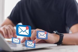 Mann, der das E-Mail-Symbol online überprüft oder E-Mails an Partner und Kunden im Web mit einem Technologiekonzept für virtuelle Schnittstellen sendet. foto