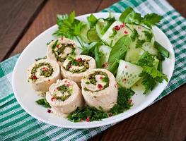 Gedämpfte Hühnerbrötchen mit Gemüse und Salat aus frischem Gemüse auf einer braunen Platte foto