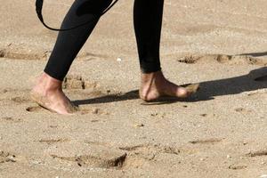 Ein Mann geht barfuß auf dem Sand am Meer foto