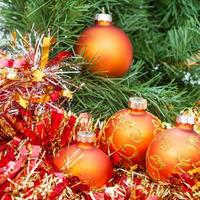 orangefarbene Weihnachtskugeln, rotes Lametta am Weihnachtsbaum 2 foto