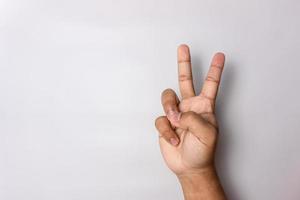 Nummer 2 Handzeichen isoliert auf weiss. Frieden Handzeichen. Mann Hand Nummer zwei Geste foto