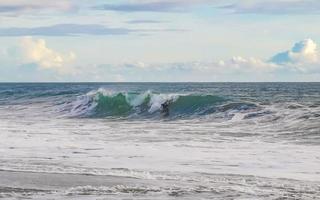 Surfer am Strand von Puerto Escondido, Mexiko, mit extrem großen Wellen. foto