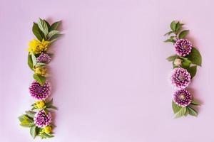 eine florale Grenze aus gelben und violetten Dahlien auf einem Stößelhintergrund. Ansicht von oben. eine Kopie des Raums. postkarte, plakat. das konzept des herbstes. foto