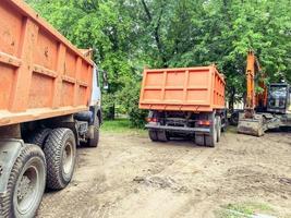 zwei Lastwagen mit einer Karosserie zum Transportieren schwerer Dinge. strapazierfähiger Aufkleber auf der Rückseite des Körpers. Baumaschinen für den Transport von Baumaterialien foto