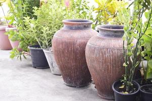 2 Terrakotta-Krüge in altem Zustand, die einen Retro-Gartenstil darstellen. foto