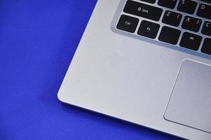 Linke Ansicht eines weißen Laptops auf blauem Hintergrund. foto