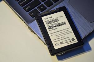 09.12.2022 chonburi, thailand ssd ist eine festplatte, die immer beliebter wird. alte festplatte, ssd wird auf den laptop gelegt. foto