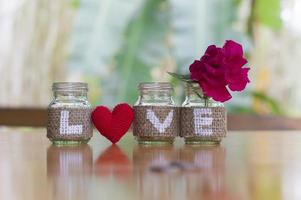 liebe auf der flasche mit rotem herzen handgefertigt für valentinstag oder hochzeitshintergrund foto