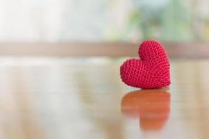 Nahaufnahme des roten Herzens handgefertigt auf Holztisch für Valentinstag oder Hochzeitshintergrund foto