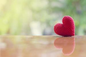 Nahaufnahme des roten Herzens handgefertigt auf Holztisch für Valentinstag oder Hochzeitshintergrund foto