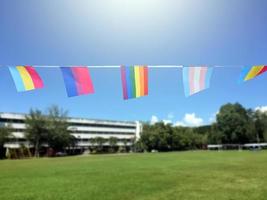 regenbogenfahnen und lgbtq-plus-flaggen wurden an einem sonnigen tag an draht gegen den blauen himmel gehängt, weicher und selektiver fokus, konzept für lgbtq-plus-gender-feiern im stolzmonat auf der ganzen welt. foto