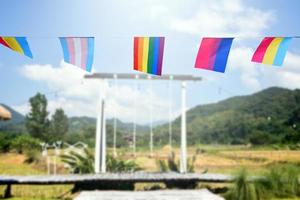 regenbogenfahnen und lgbtq-plus-flaggen wurden an einem sonnigen tag an draht gegen den blauen himmel gehängt, weicher und selektiver fokus, konzept für lgbtq-plus-gender-feiern im stolzmonat auf der ganzen welt. foto