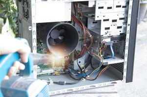 Reinigung eines staubigen Computers mit einem Gebläse. foto