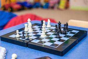 Schachbrett-Seitenansicht, Hand, die eine Schachfigur bewegt, kurz davor, sie zu greifen, Nahaufnahme. bewegen, strategie, planung, herausforderung und erfolg abstraktes lifestyle-konzept foto