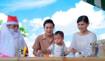 asiatische familie, die färbung mit dem kleinen jungen spielt foto