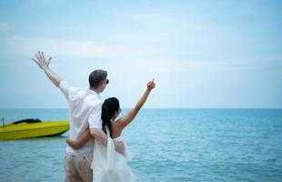 interrassisches Paar mit der Freude, zum wunderschönen blauen Meer wie ins Paradies zu reisen foto