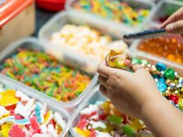 Süßigkeiten werden in Schachteln und kleinen Körben mit Geleebonbons in verschiedenen Farben verkauft. Käufer holen Gläser ab. foto