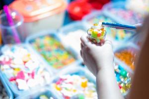 Süßigkeiten werden in Schachteln und kleinen Körben mit Geleebonbons in verschiedenen Farben verkauft. Käufer holen Gläser ab. foto