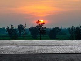 leerer holztisch wald natur hintergrund orange himmel in der dämmerung platz für display-werbung foto