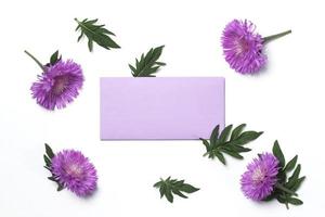 einladungs- oder grußkartenmodell mit leerem lila umschlag mit distelblumen auf weißem hintergrund foto