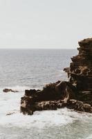 tagsüber braune Felsformation am Meer foto