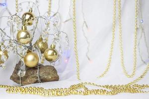 weihnachtshintergrund mit einem weihnachtsbaum, an dem kleine goldene kugeln hängen. selektiver Fokus, ein Bild für den Hintergrund. das konzept von weihnachten und neujahr. foto
