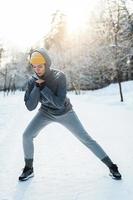 junge sportliche Frau, die sich vor ihrem Wintertraining aufwärmt foto