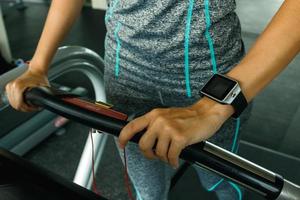 Nahaufnahme der weiblichen Hand mit intelligenten Uhren im Fitnessstudio foto