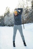 junge sportliche Frau, die sich vor ihrem Wintertraining aufwärmt foto