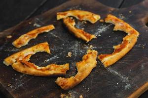 Knusprige Krusten von leckerer Pizza auf dem Holzbrett foto