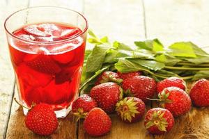 Erfrischungsgetränk mit Erdbeere auf Holztisch foto