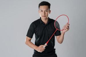 Badmintonspieler, der Sportkleidung trägt und einen Schläger hält foto