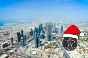 frohe weihnachten dubai, dirham-münze mit weihnachtsmann-hut auf dubai-stadthintergrund. Grußkarte. foto